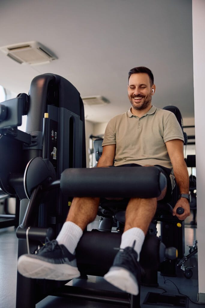 happy athletic man exercising on leg extension mac 2024 12 13 23 04 32 utc